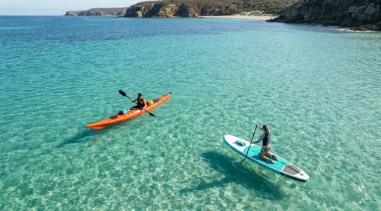 Vue aérienne d'un kayak et d'un paddle côte à côte sur des eaux turquoise peu profondes, prêts pour une exploration côtière