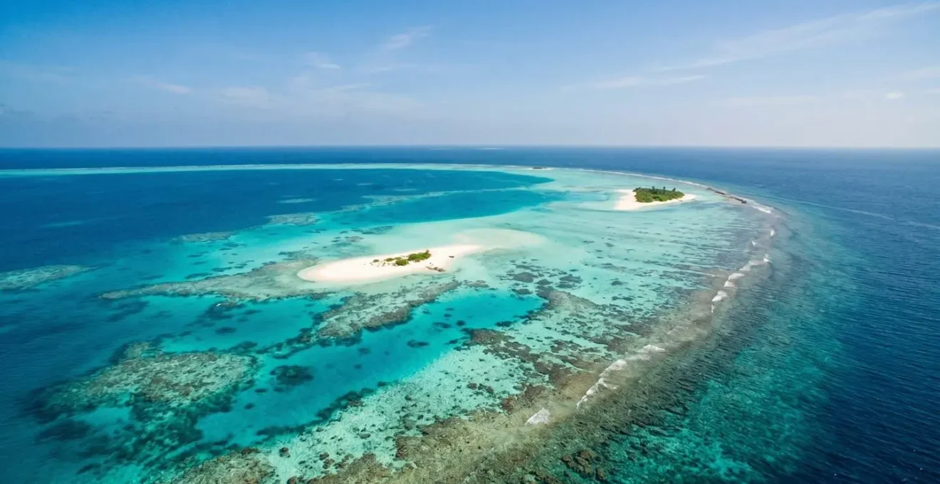 Vue aérienne spectaculaire d'un atoll maldivien avec eaux cristallines pour illustrer le transfert en hydravion